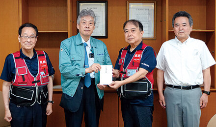 見舞金の目録を水足熊本県医会長に手交する松本会長（左から2番目）